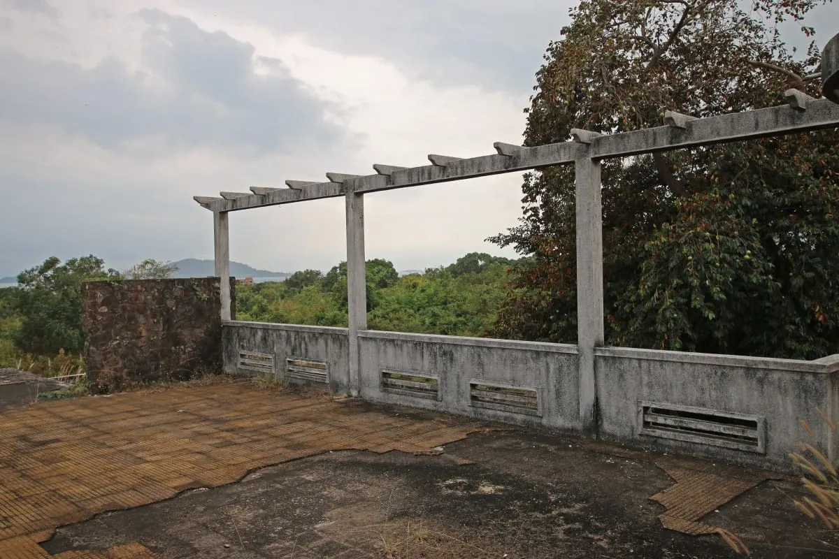 Concrete pergola on the cracked terrace of an abandoned villa overlooking Kep.