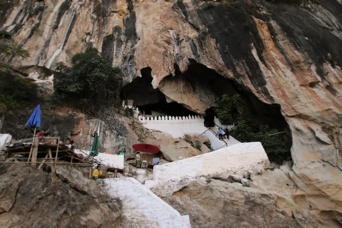 White stairs climbing a limestone cliff to the Pak Ou Caves entrance above the Mekong
