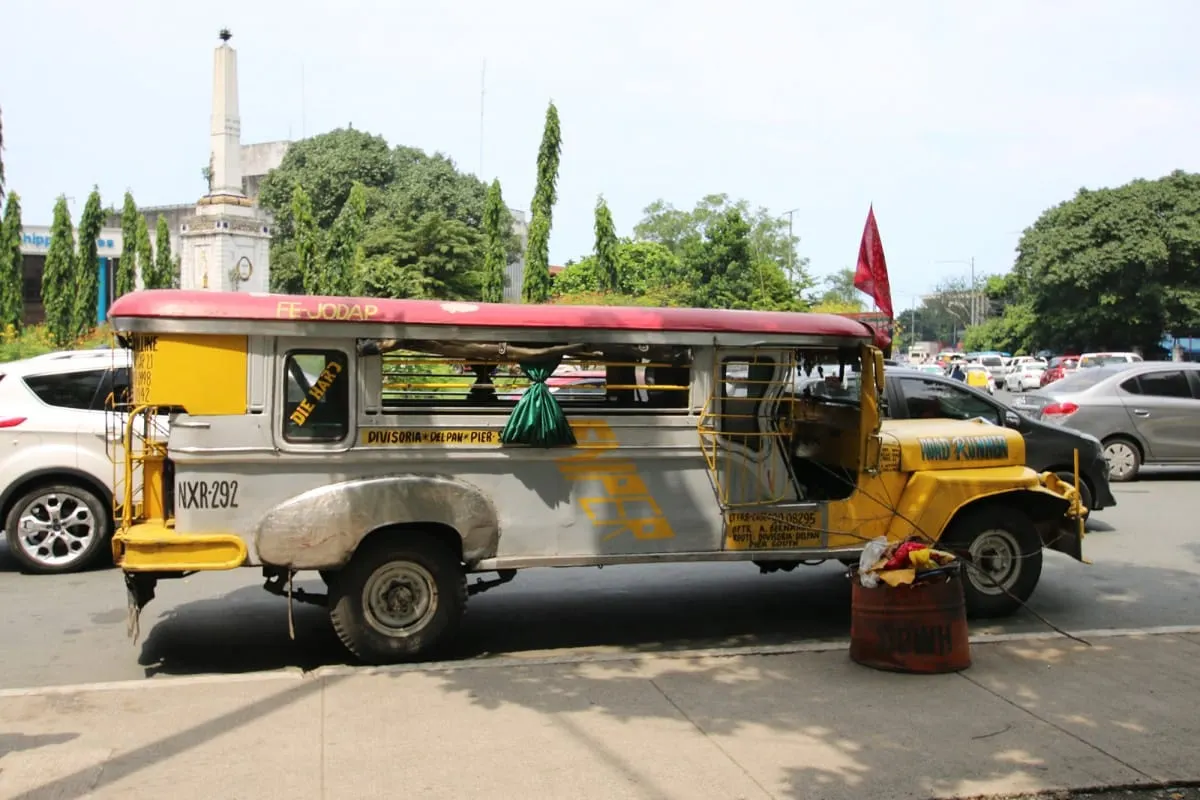 Silver and yellow jeepney parked on a Manila street