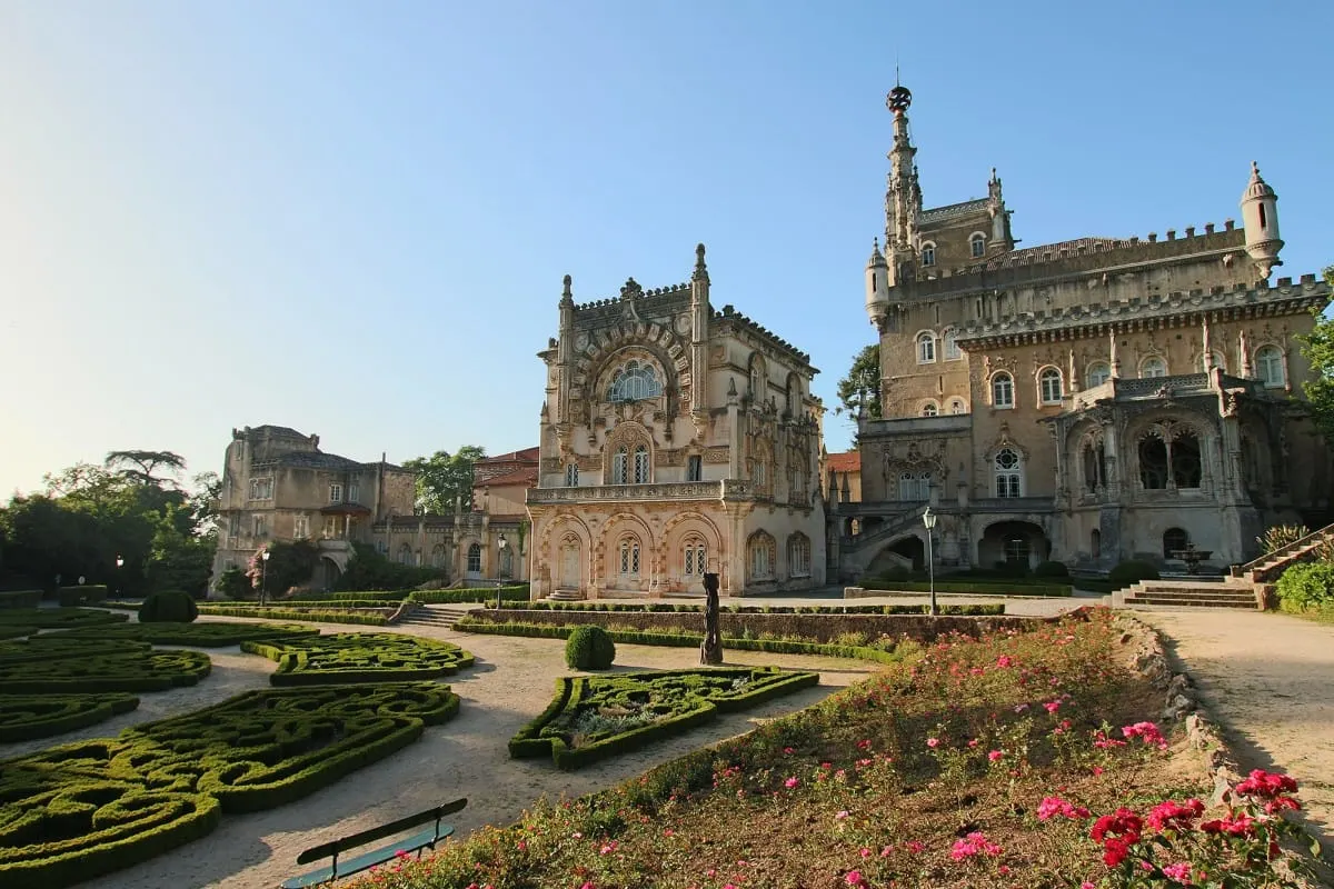 Bussaco Palace rising above clipped box hedges and pink rose beds