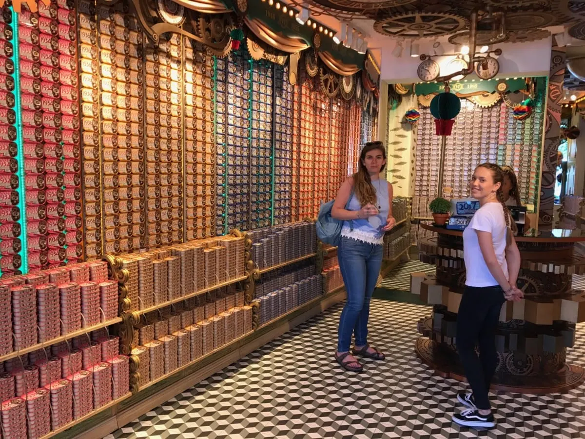 Two women in a Porto shop lined floor to ceiling with sardine tins