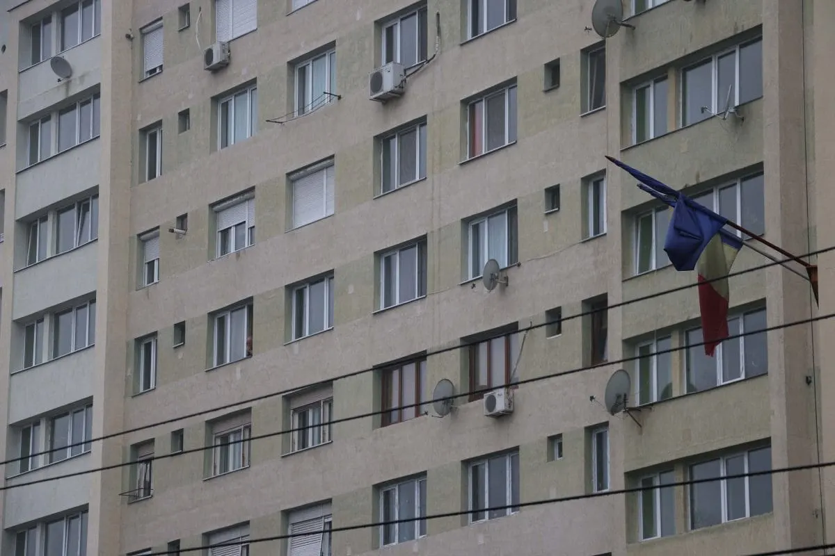 Apartment block facade with a tattered Romanian flag