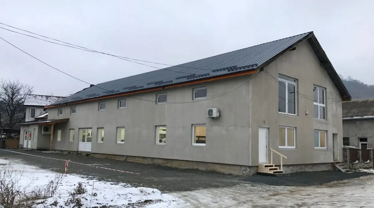 New gray two-story building with snow on the ground