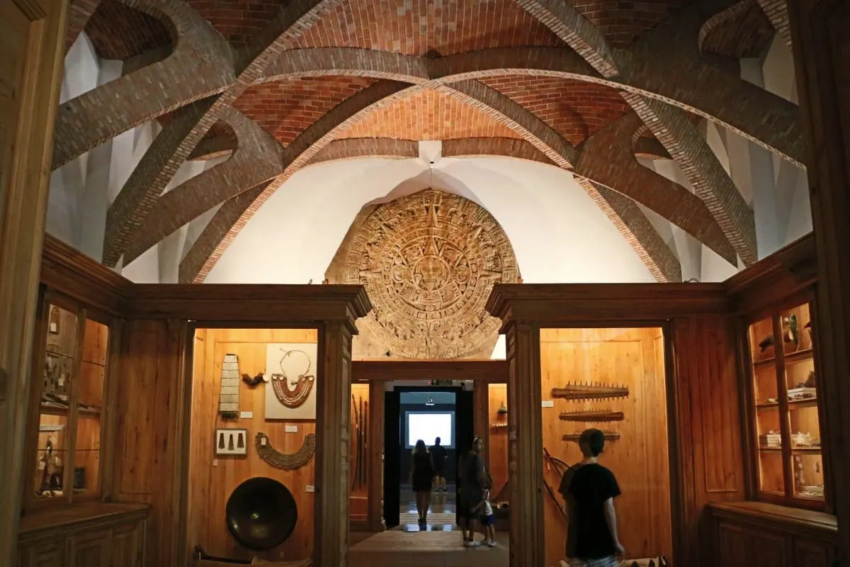 Aztec sun stone replica beneath brick vaulting in Madrid's Museo de America