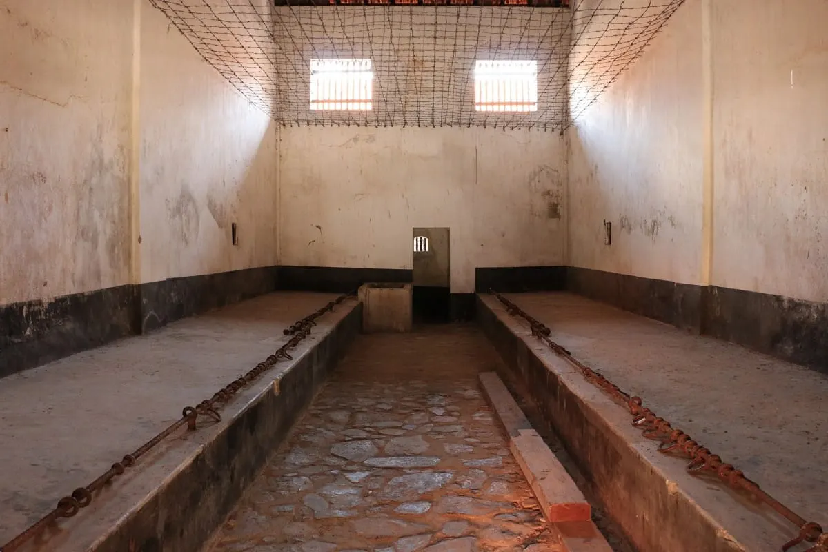 Empty communal cell with concrete platforms and leg-shackle bars, Con Dao prison