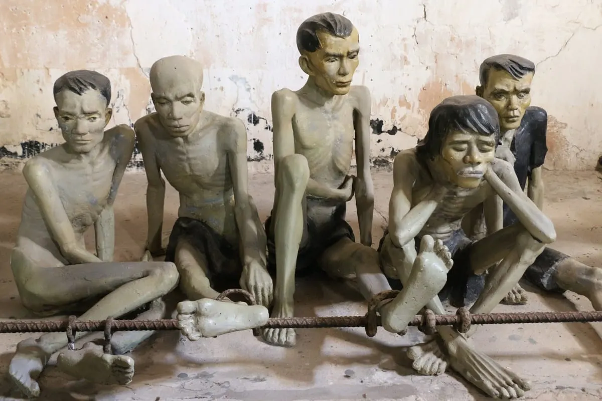 Statues of emaciated prisoners shackled to an iron bar, Con Dao prison